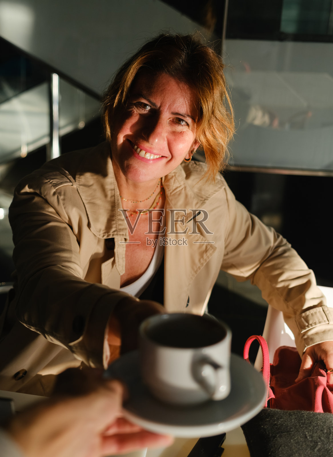 休息时间，一位女士微笑着递上咖啡照片摄影图片