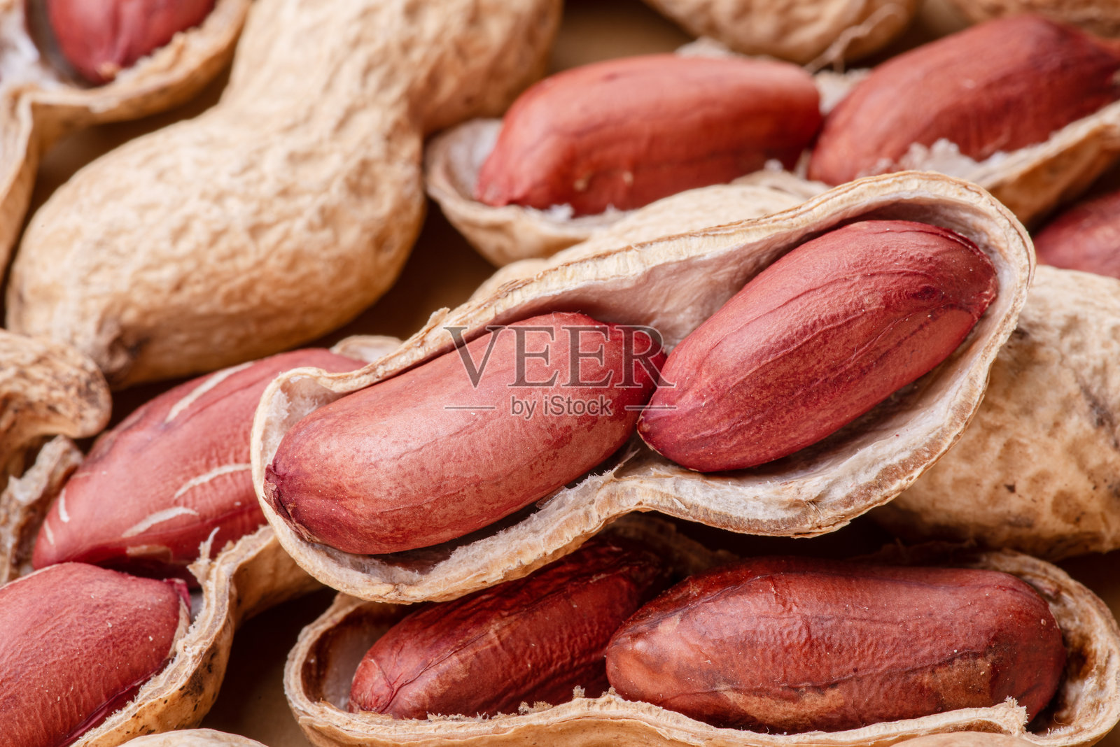 一堆完整和裂开的花生特写。食物背景。照片摄影图片