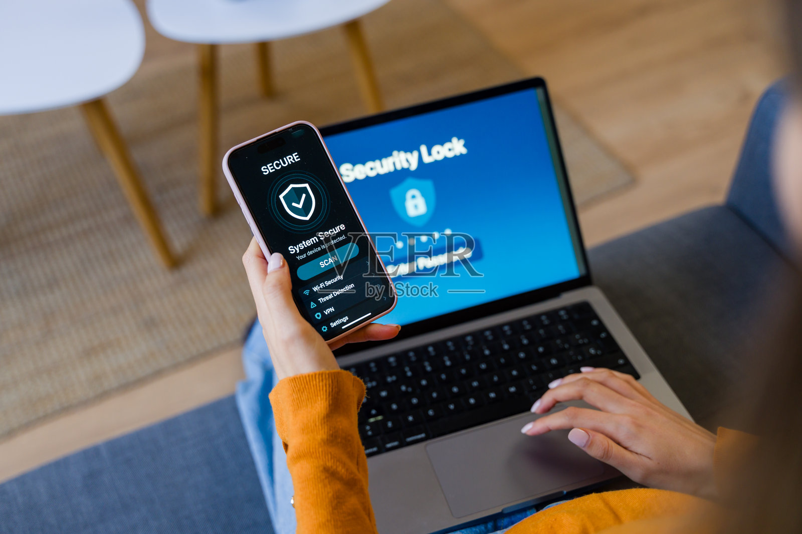 女性使用安全锁将智能手机应用程序连接到笔记本电脑照片摄影图片