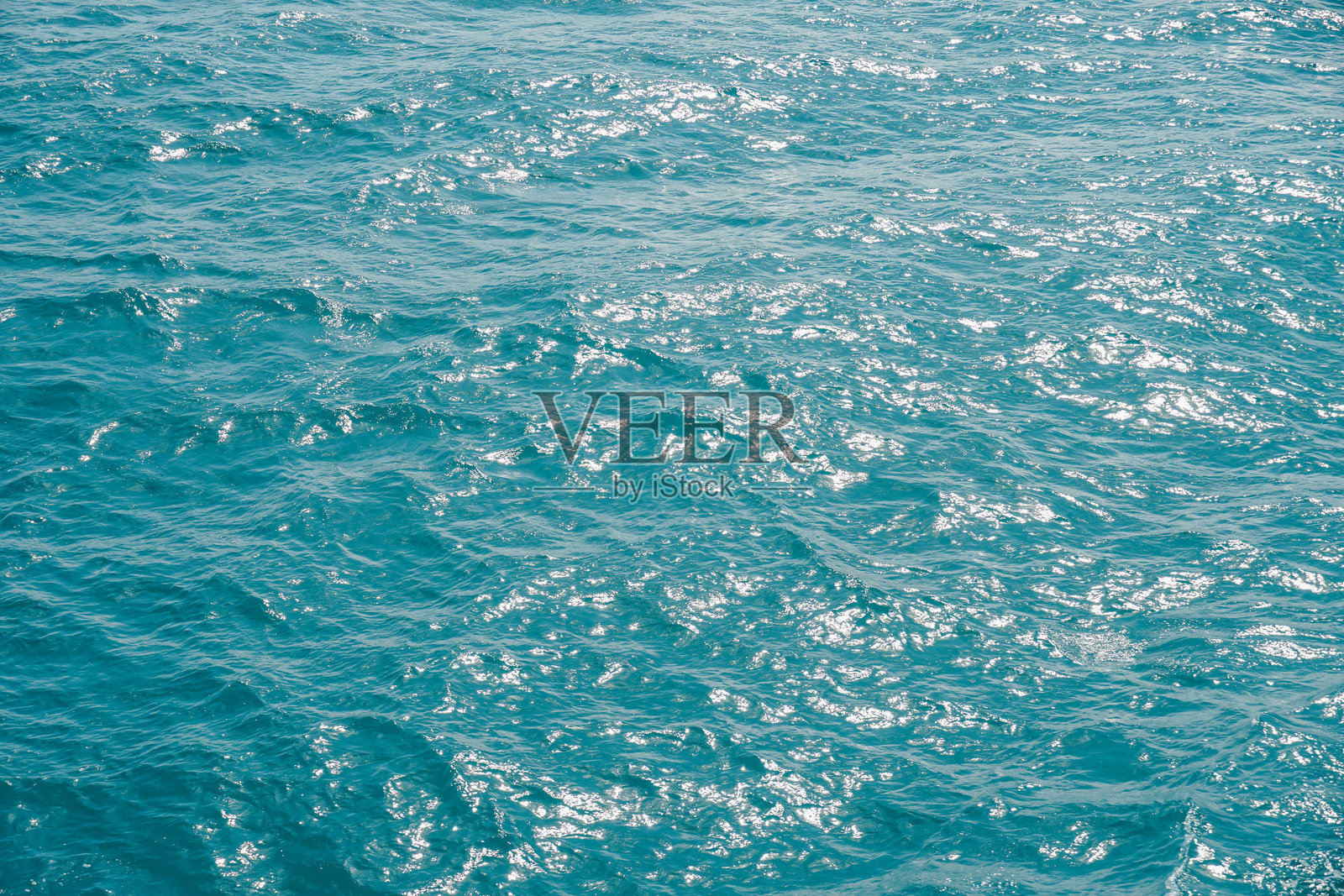 海浪纹理特写。深蓝色水面带有涟漪背景。河流中带有动态模糊的微距蓝色波浪图案。平静的水面反射着闪耀的阳光。照片摄影图片