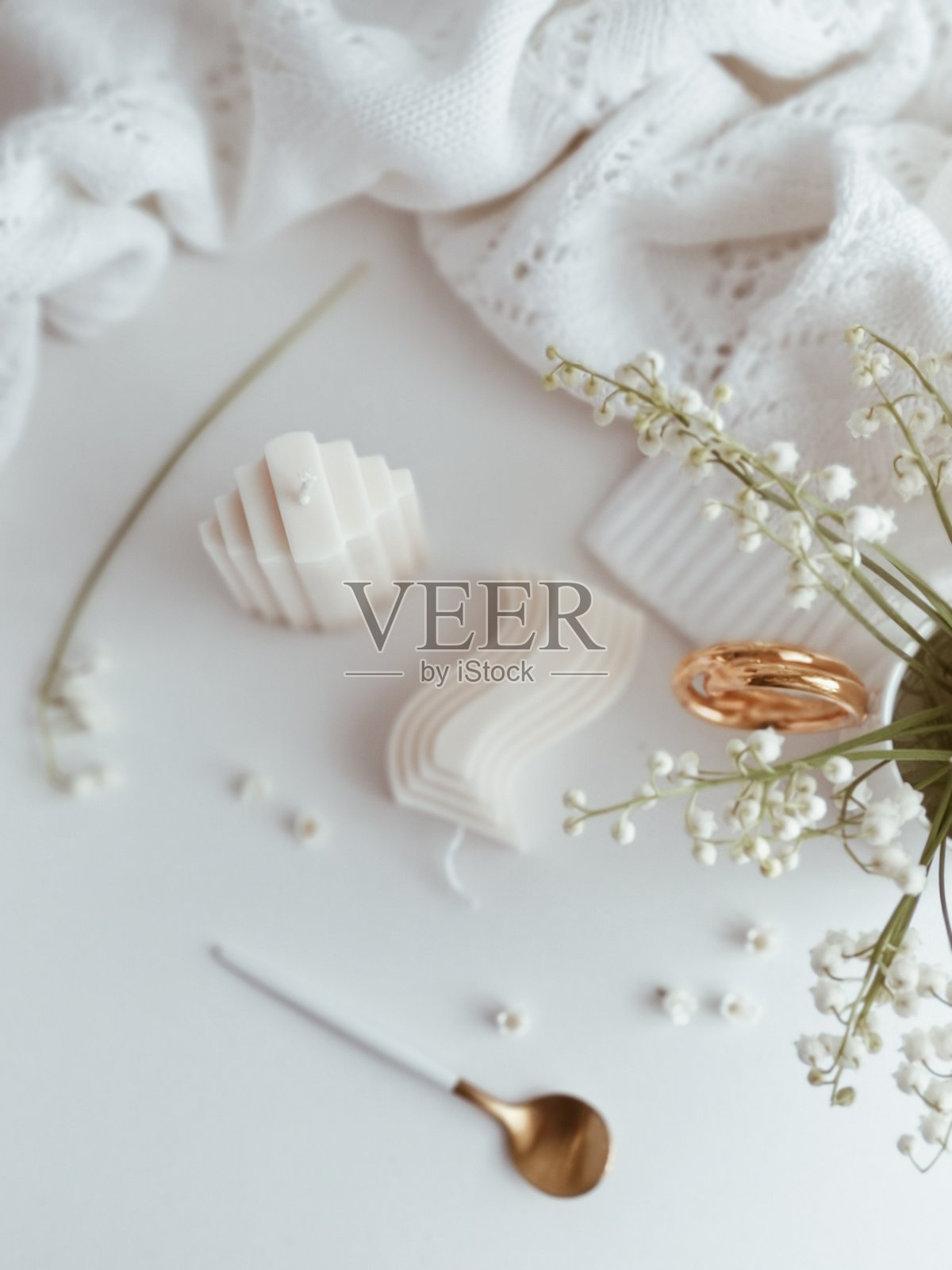 优雅的白色蜡烛圣诞装饰，搭配铃兰花和羊毛毛衣照片摄影图片