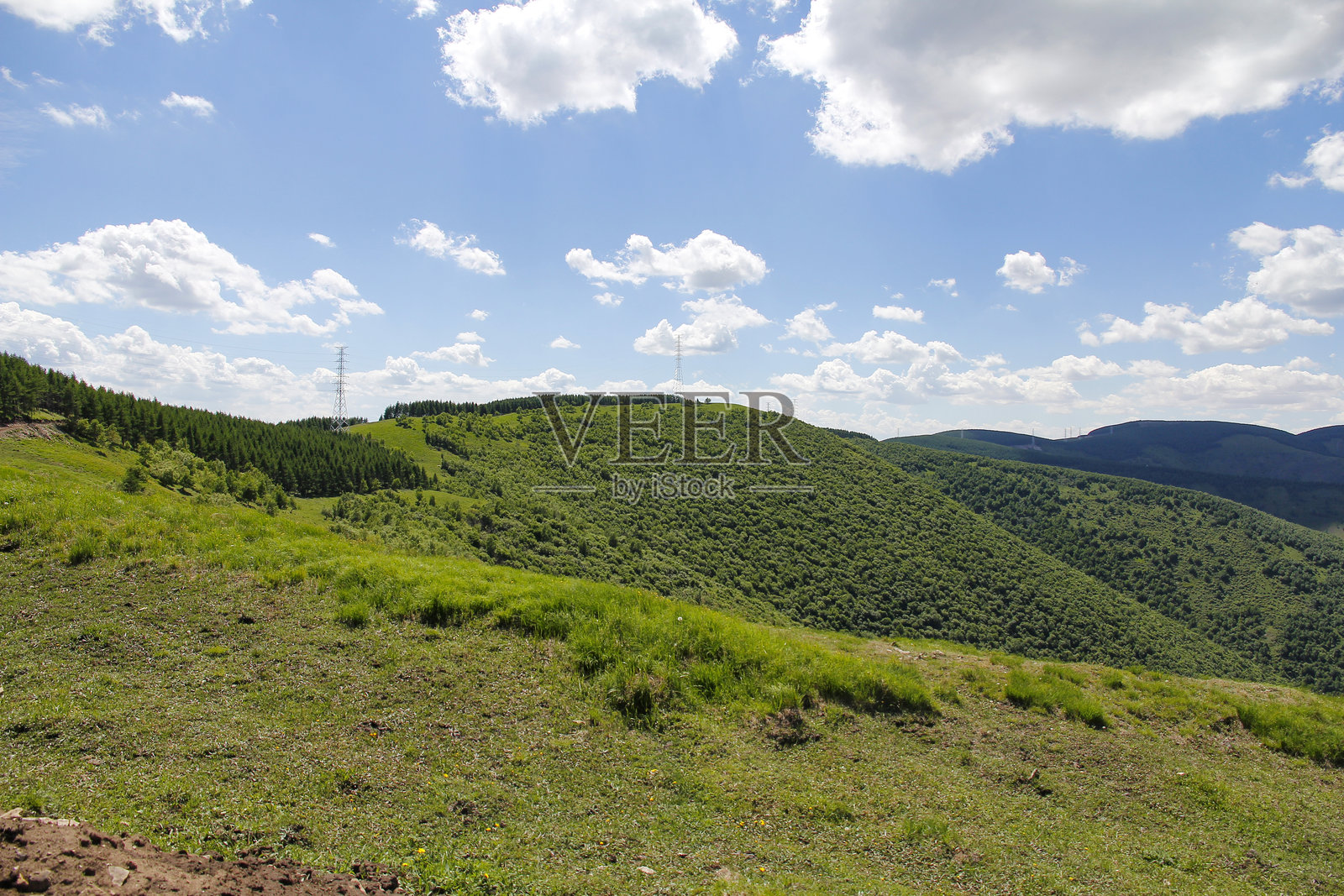 蓝天白云下的绿色山丘照片摄影图片