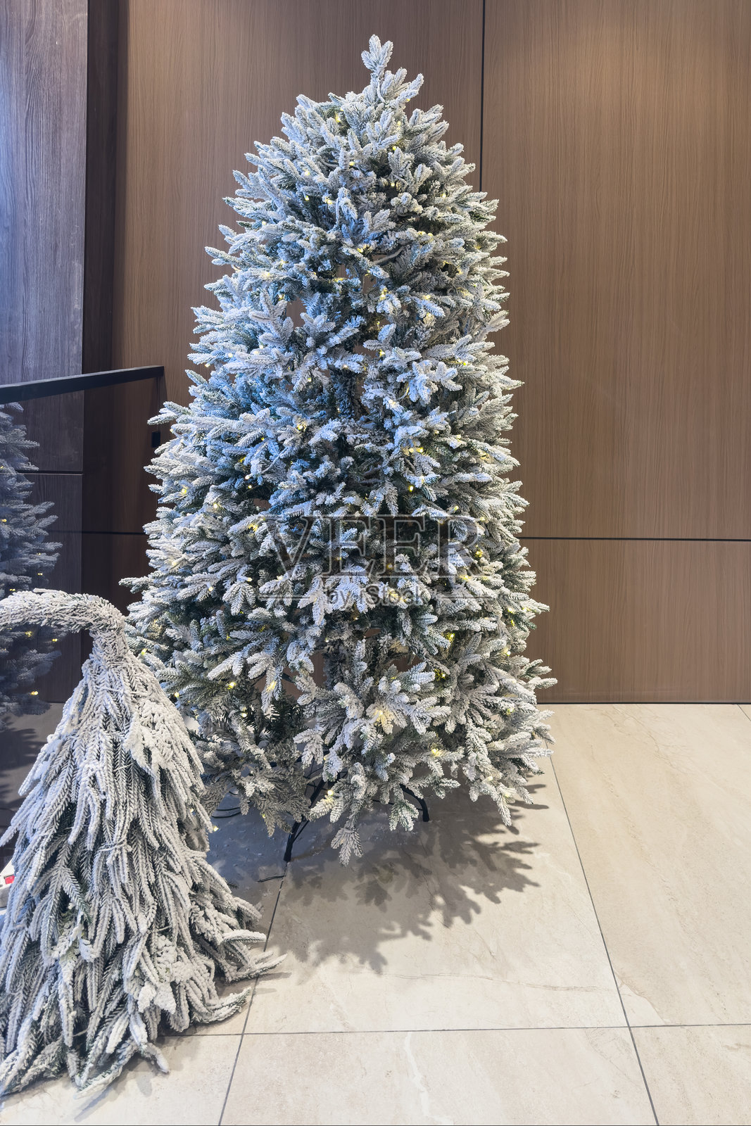 一幅优雅的节日圣诞装饰，带有两棵人造圣诞树，展现冬日假期的喜悦。照片摄影图片