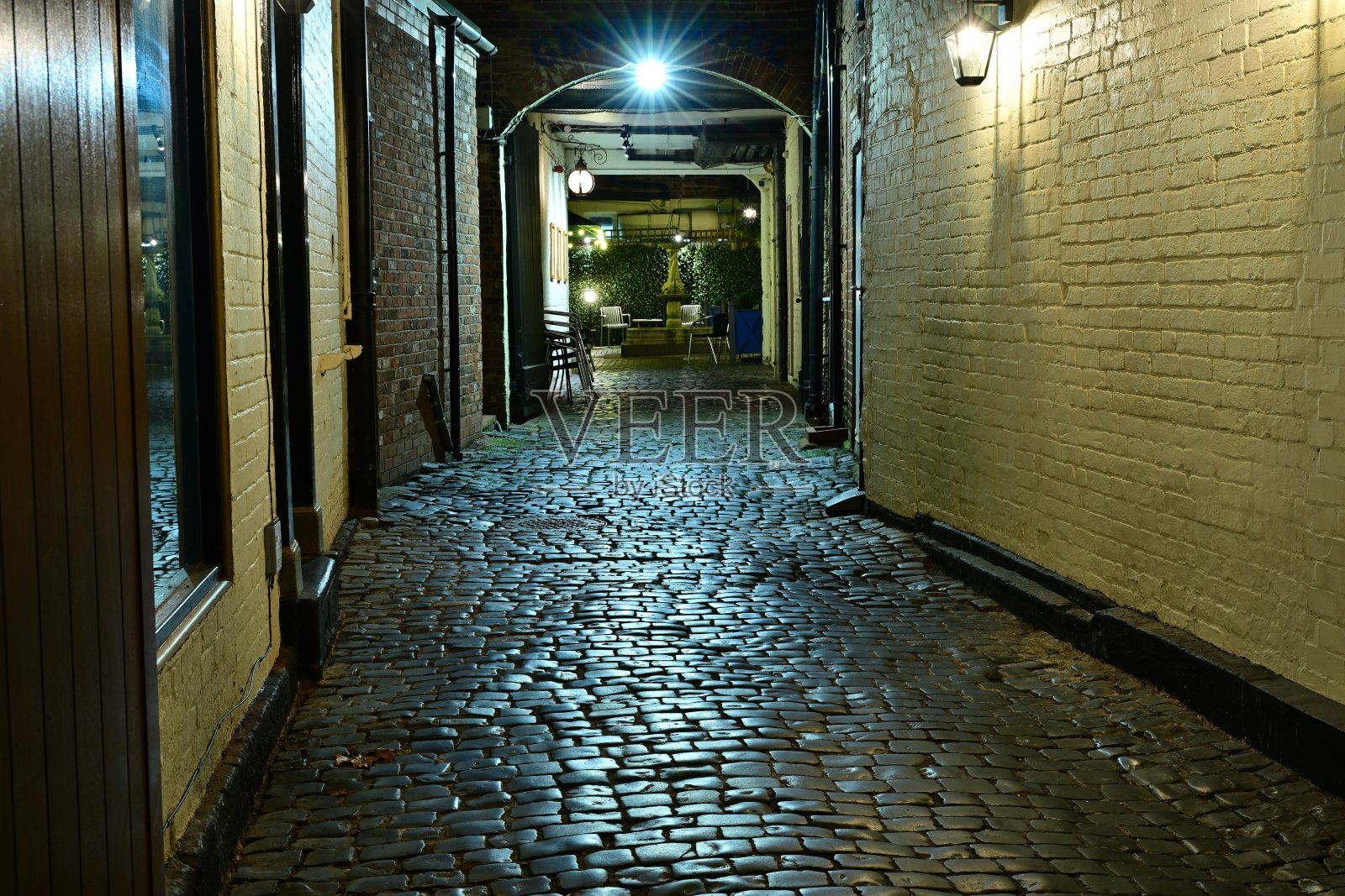 狭窄的砖砌小巷，有灯笼灯和户外座位区照片摄影图片