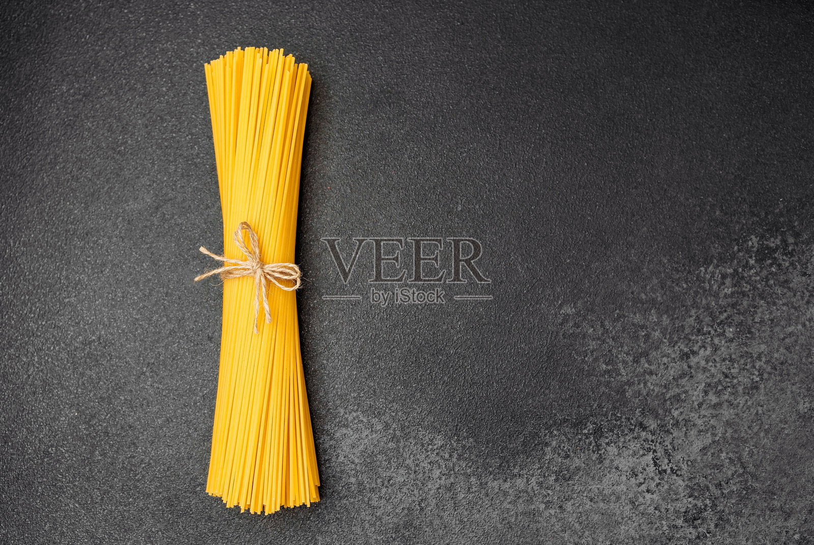深色表面上的干意面束，准备用于烹饪食谱照片摄影图片