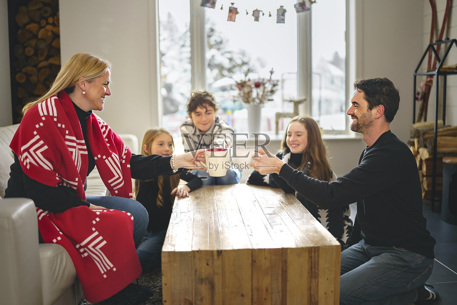 一家人在家里的咖啡馆，靠近壁炉，享受热饮照片摄影图片