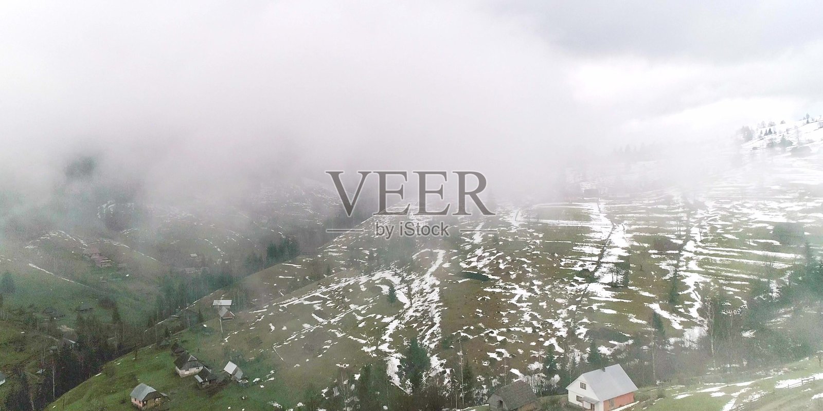 俯瞰山村和雾气缭绕的绿色田野照片摄影图片