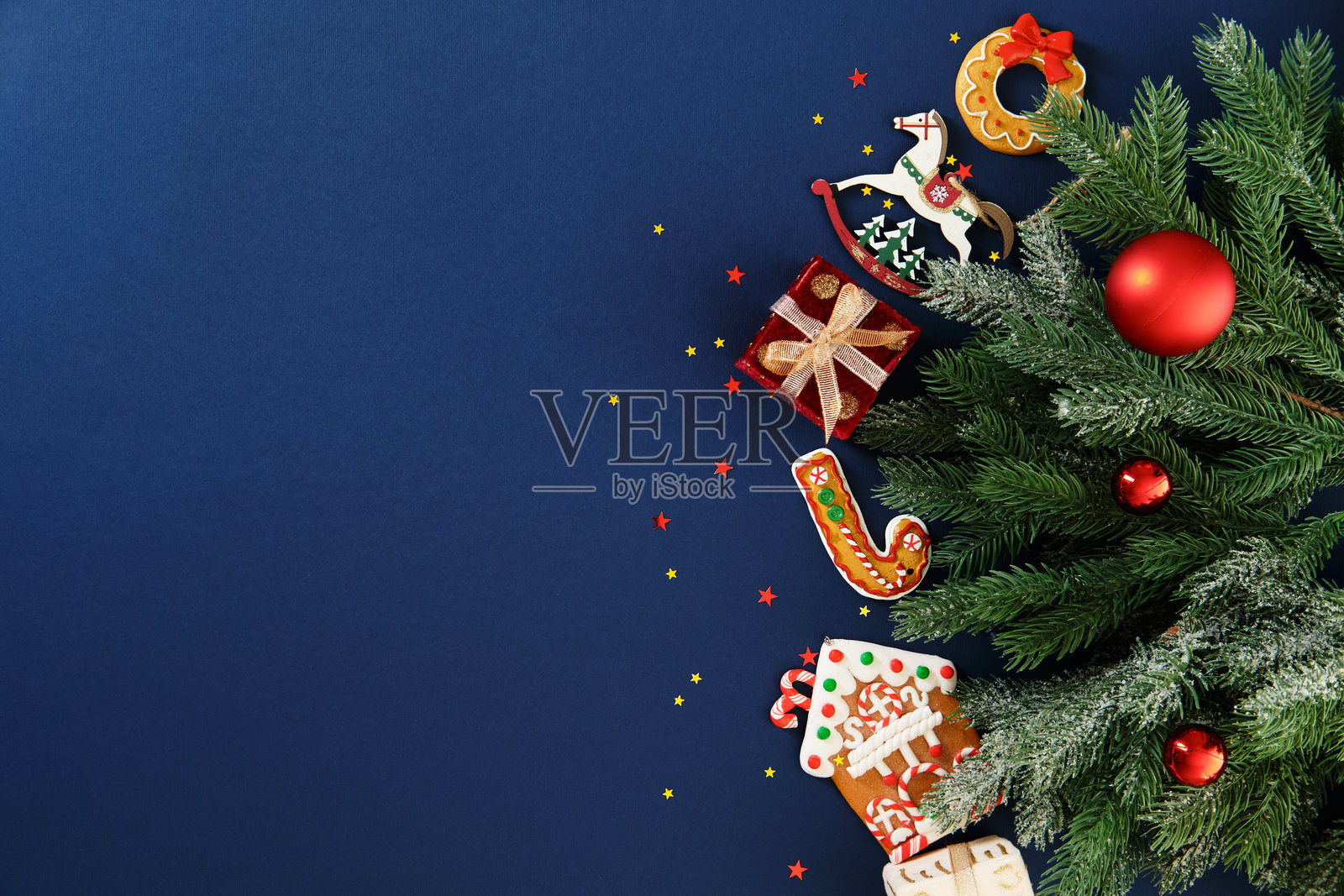 右侧有蓝色圣诞背景，带有松枝和装饰品，留有复制空间。照片摄影图片