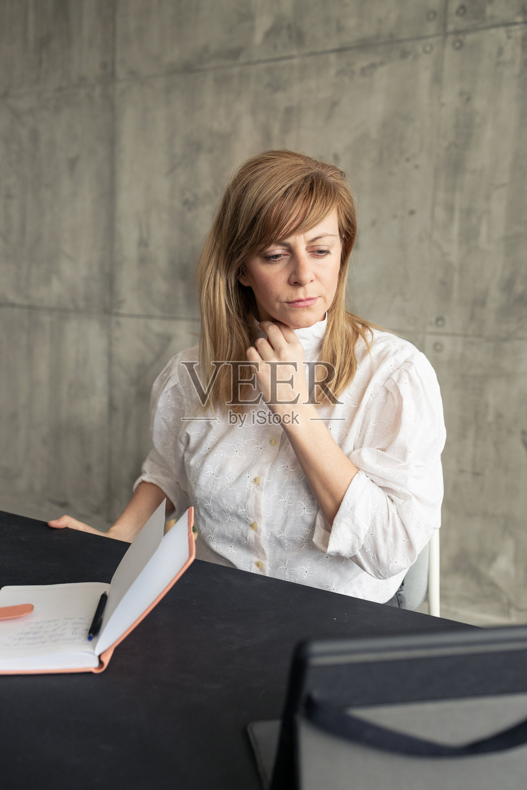 女商人通过视频通话阅读笔记时触摸脖子照片摄影图片