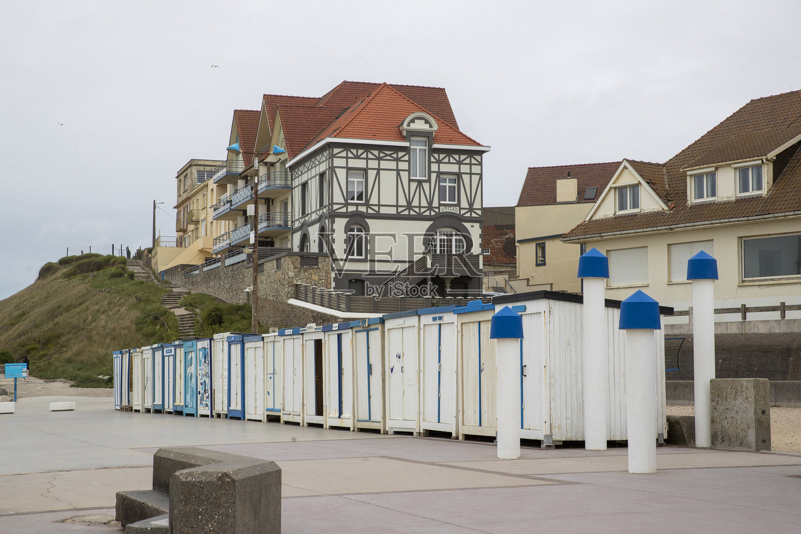 Wimereux 海滨长堤上的白色和蓝色沙滩小屋。照片摄影图片