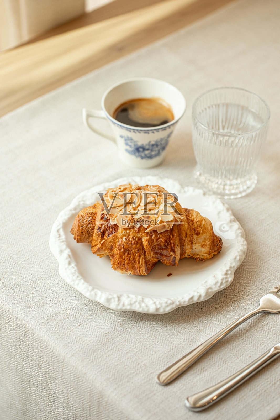 白色盘子里的杏仁可颂配咖啡照片摄影图片