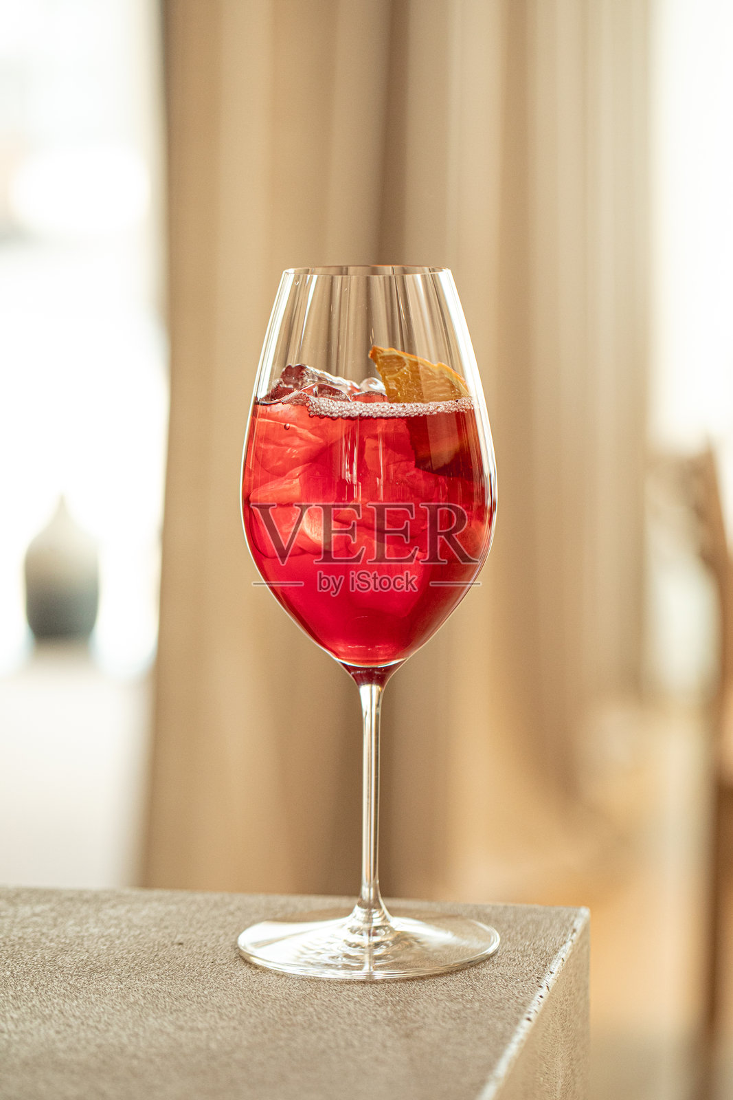 酒杯中带有橙子和冰块的红色鸡尾酒照片摄影图片