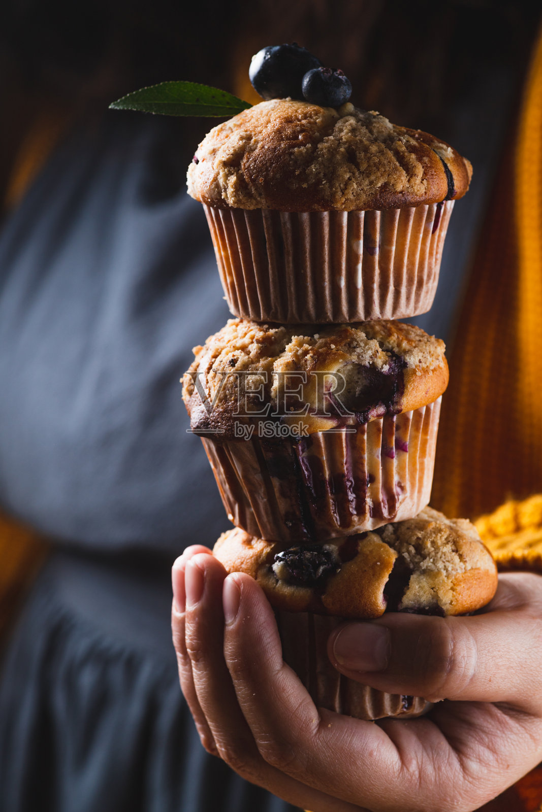 女人手中叠放的蓝莓玛芬照片摄影图片