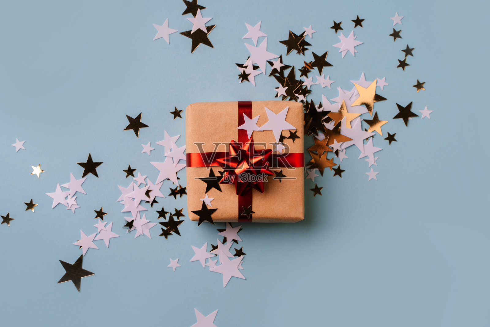 带红色蝴蝶结和星星纸屑的礼品包装照片摄影图片