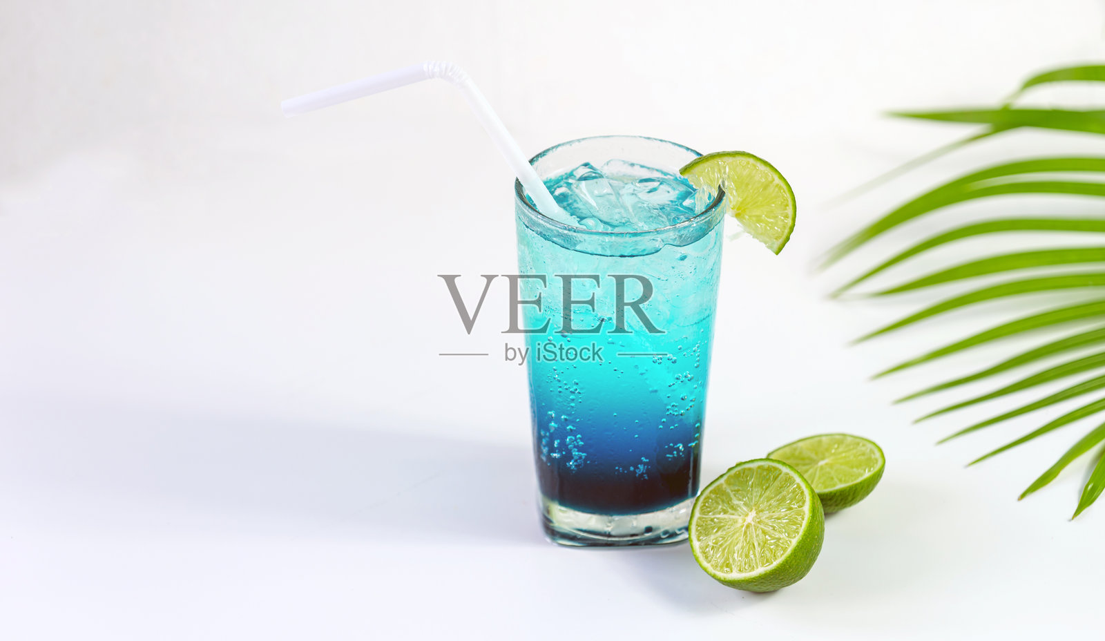 蓝色的夏威夷鸡尾酒配青柠，置于白色背景上照片摄影图片