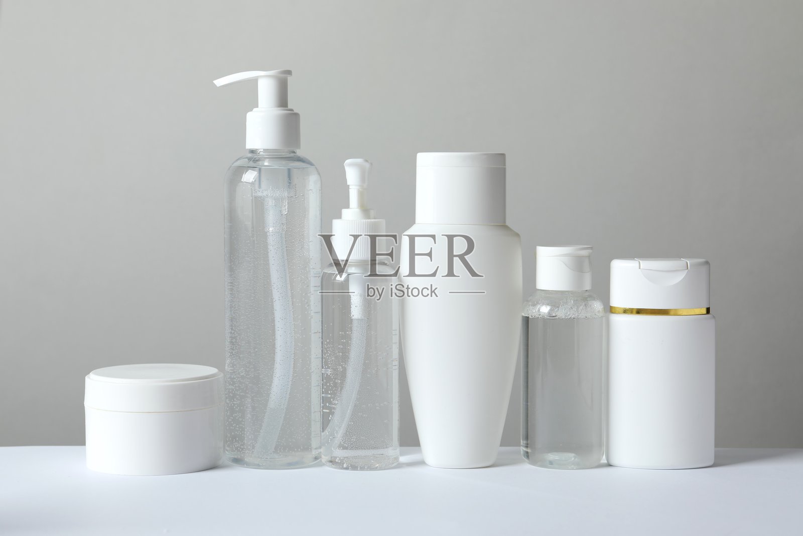 护肤品包装套装，包括罐子、滴管瓶和管子，置于灰色背景上。照片摄影图片