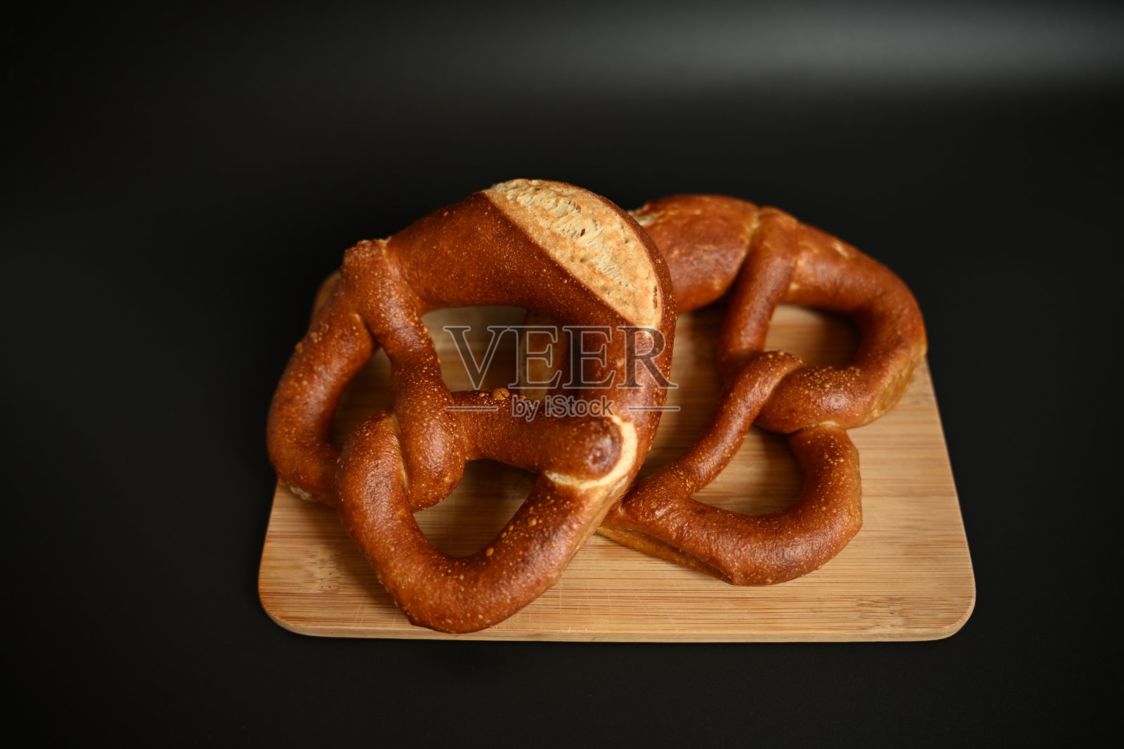 德国美食：切板上的两个传统椒盐卷饼照片摄影图片