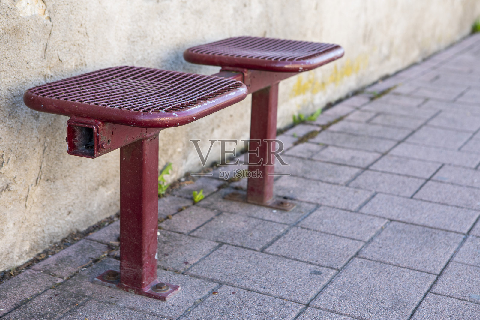 人行道上的公交车站有两个金属座椅，留有复制空间照片摄影图片