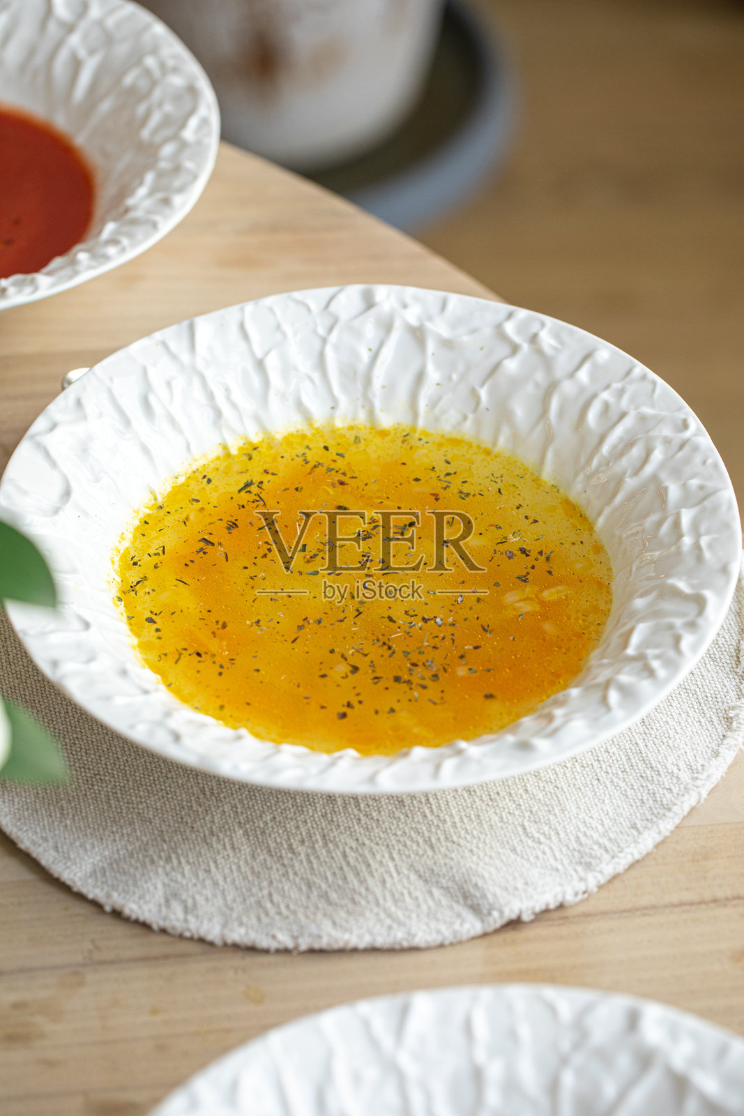 白碗里盛着清澈的鸡汤，配有香草照片摄影图片