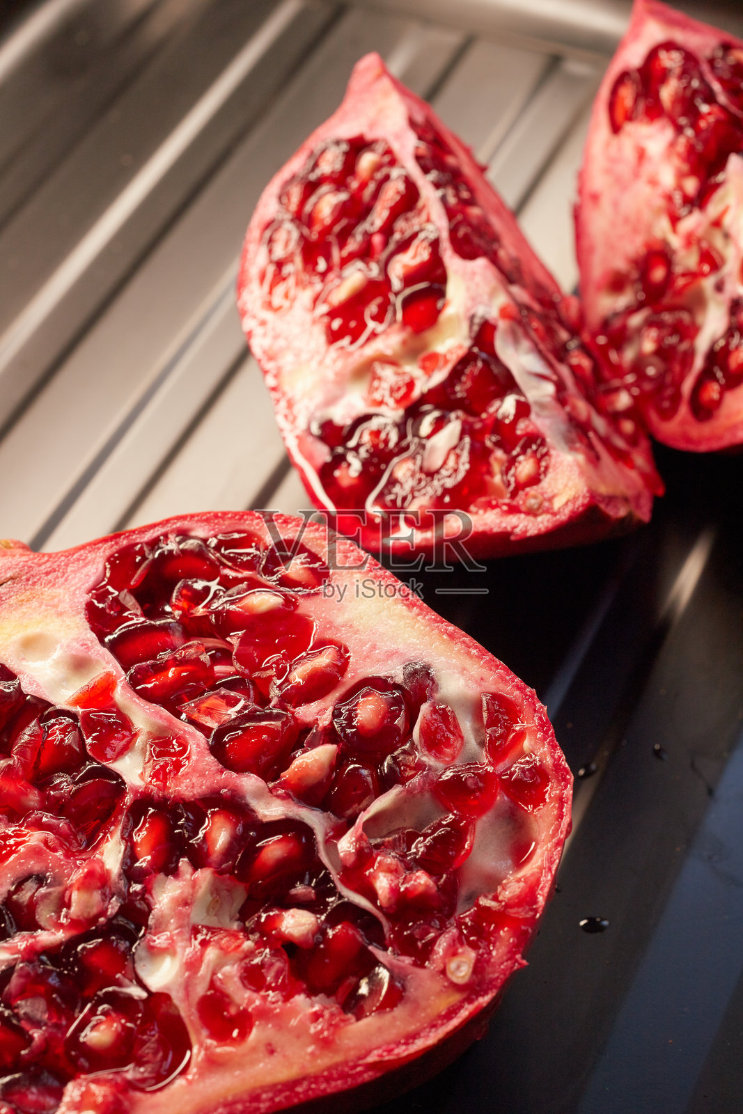 金属网格上几块生石榴的特写，自然纹理和光线，美食摄影照片摄影图片