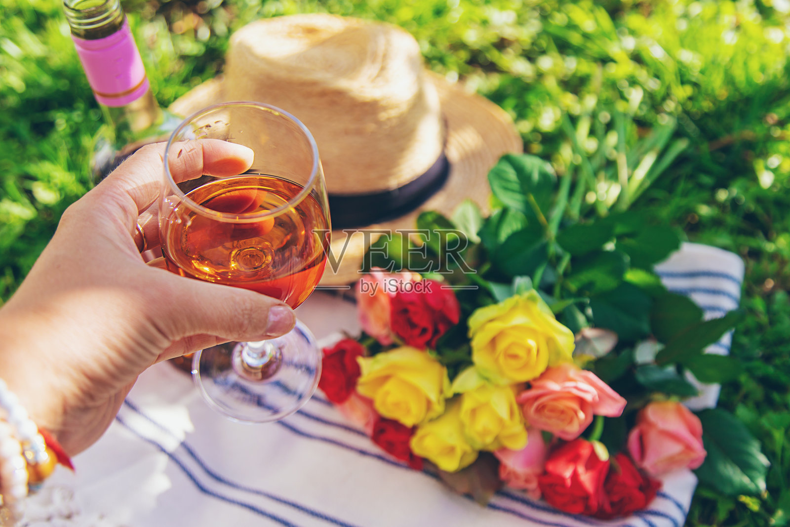 花园里有酒和鲜花的野餐，一位女士。焦点选择。照片摄影图片