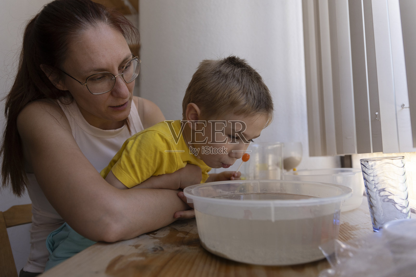 妈妈在水里帮男孩吹泡泡玩照片摄影图片