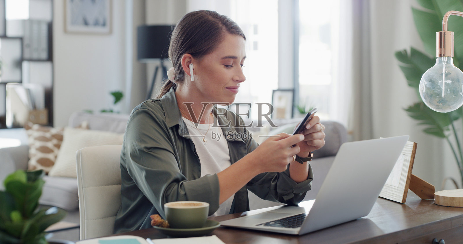 笔记本电脑、耳机和手机，在家中用于播放音乐、编辑文章或远程工作。自由记者、人物和科技产品在公寓中用于播客流媒体、搜索歌曲或出版。照片摄影图片