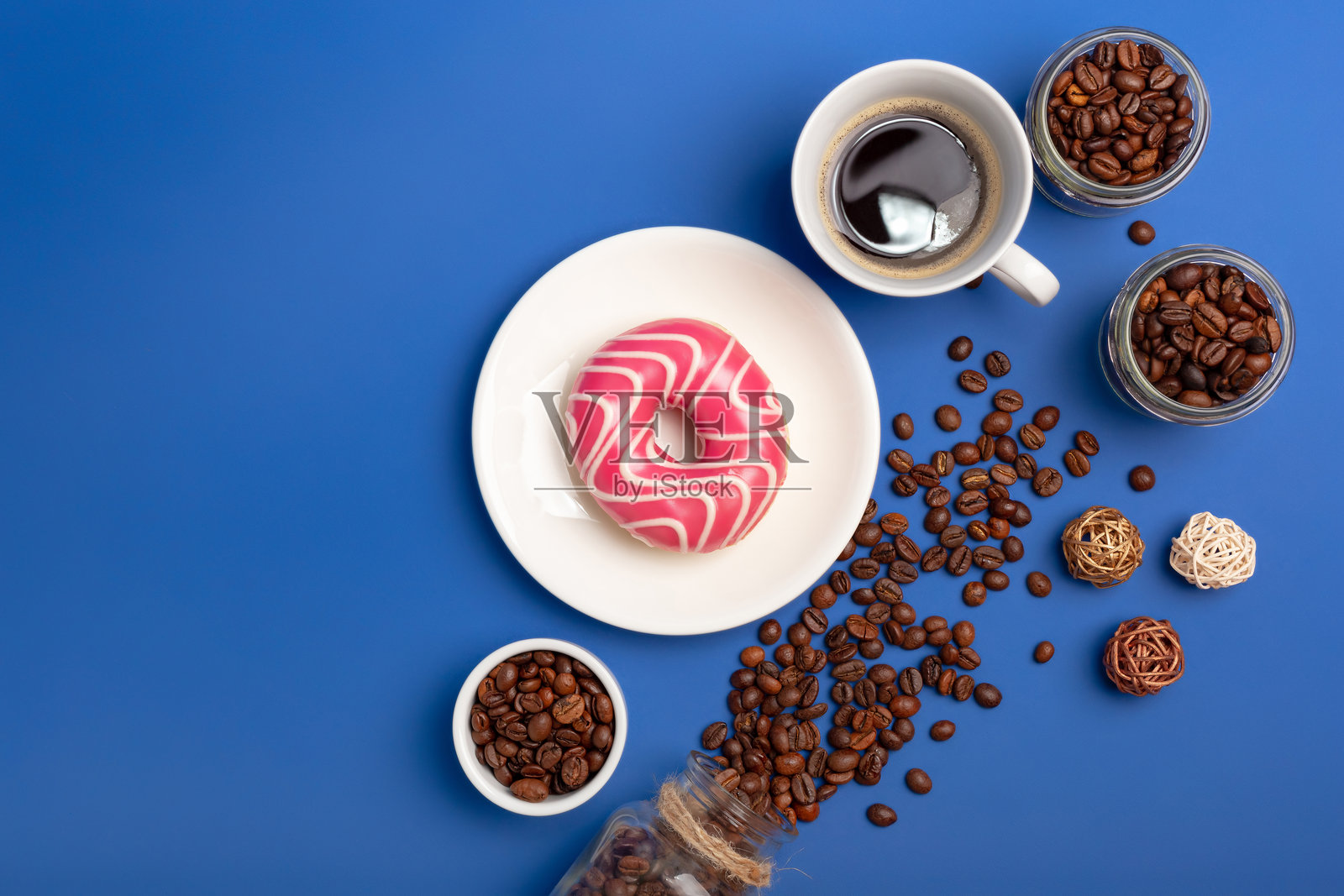 甜甜圈和咖啡杯，烘焙的咖啡豆。照片摄影图片