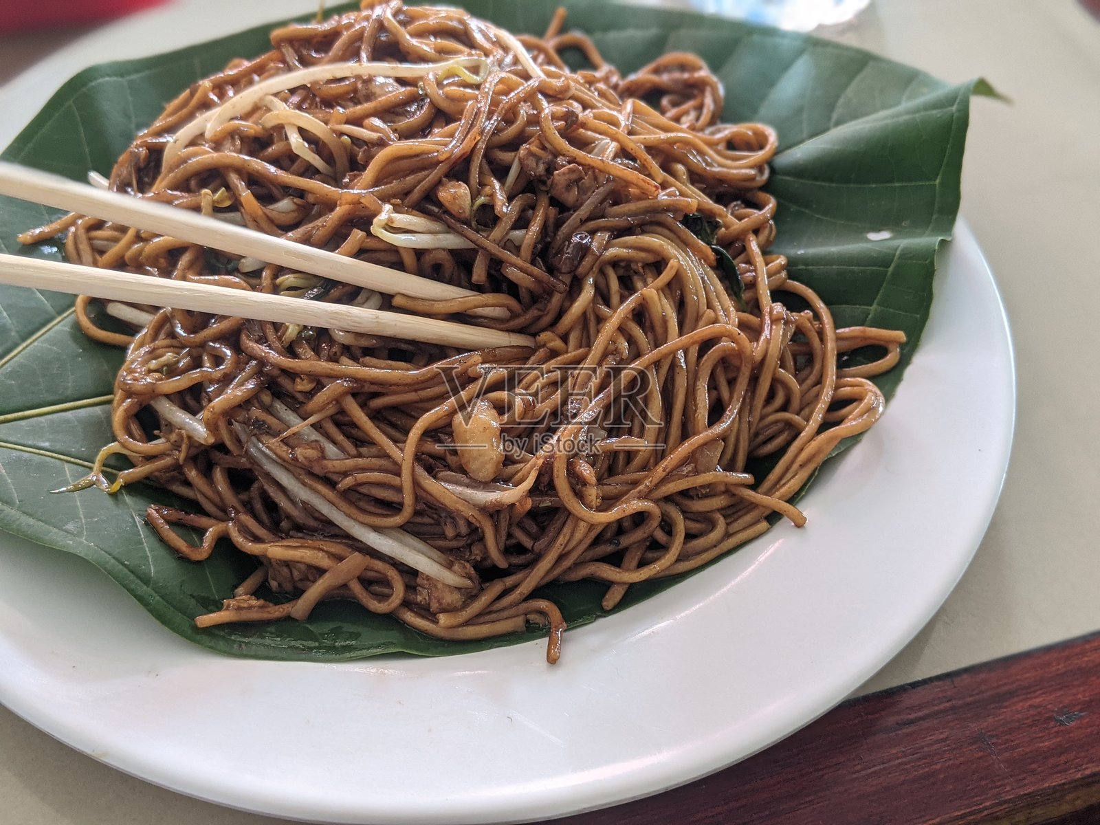 玻璃盘里烤焦的面条，配有叶子工具照片摄影图片