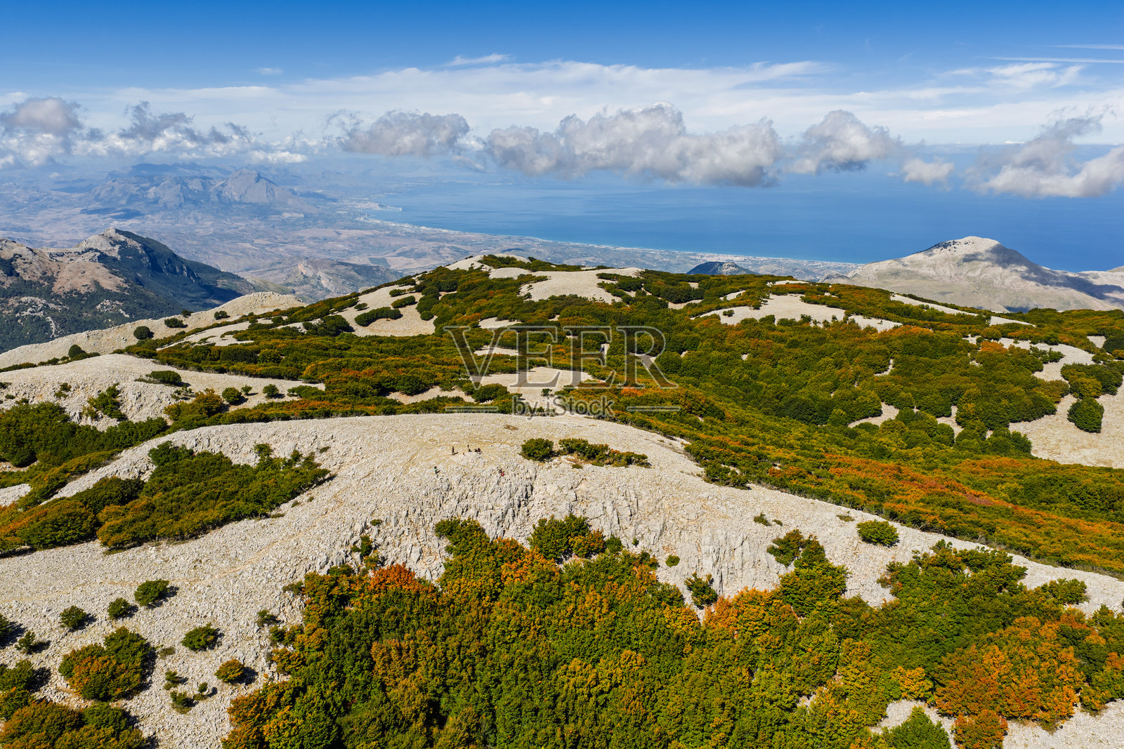 从空中无人机视角拍摄的意大利西西里岛马多尼山脉的卡波纳拉山。这里展示了崎岖的石灰岩山脊、高山草甸和第勒尼安海。地点：西西里岛，巴塔利亚山口。照片摄影图片