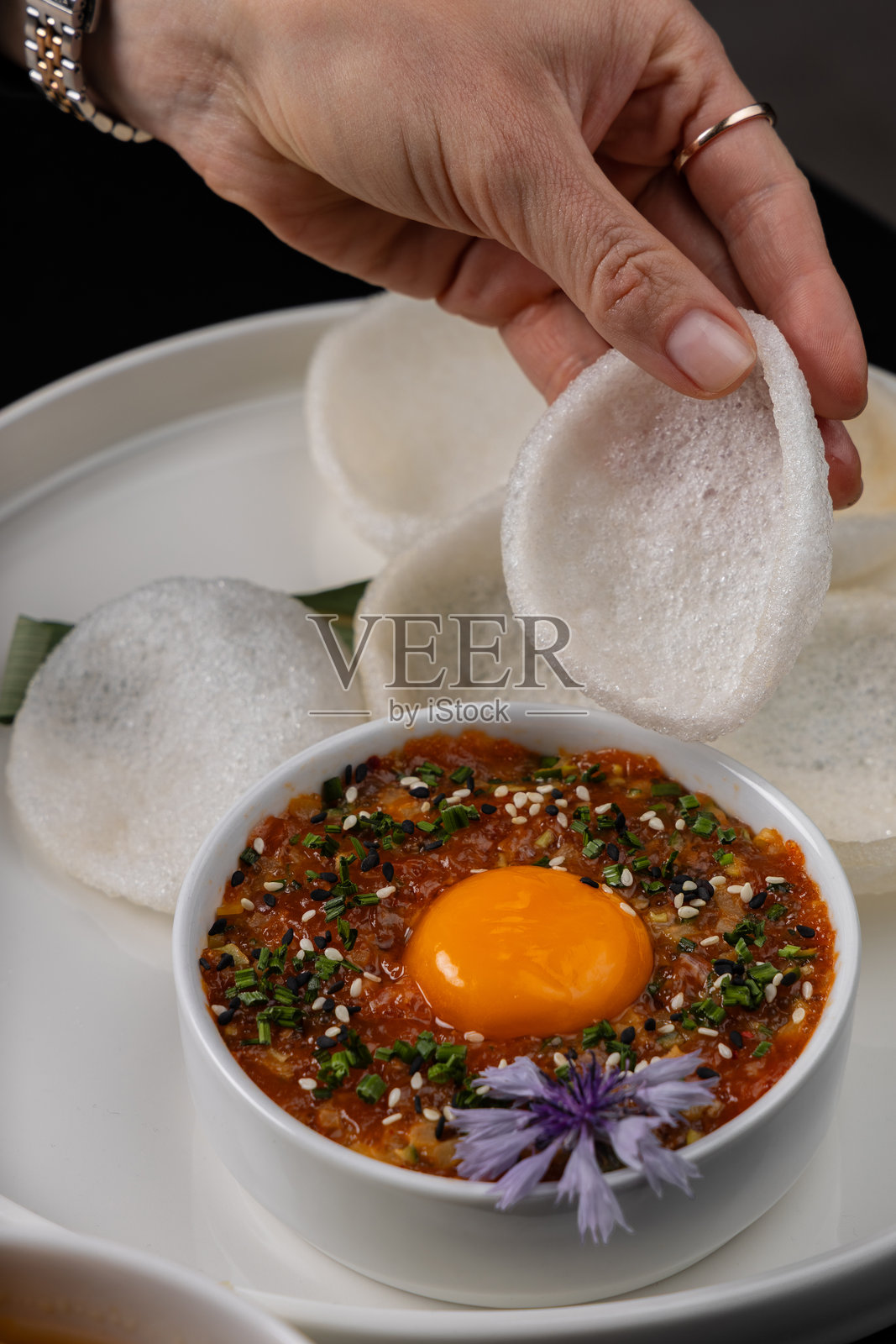 女孩用米片蘸着蛋黄吃塔塔酱照片摄影图片