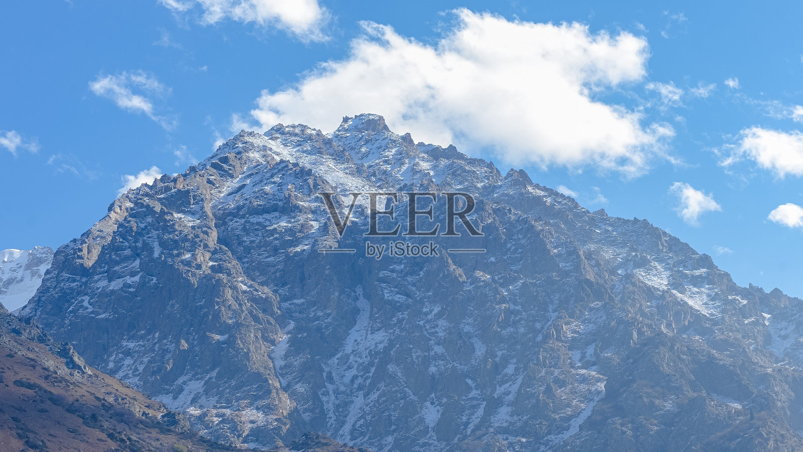 巍峨的雪山之巅耸立在湛蓝的天空下，在宁静的风景中展现出崎岖的地形和自然之美照片摄影图片