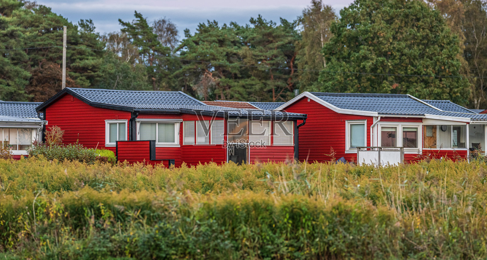 乡村里的红木屋，饰有白色镶边。照片摄影图片