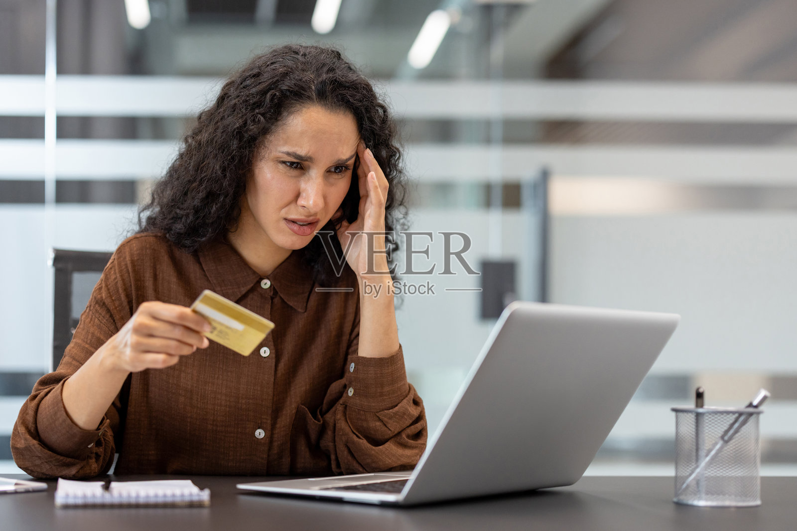 压力山大的女性正在用信用卡进行网上支付照片摄影图片