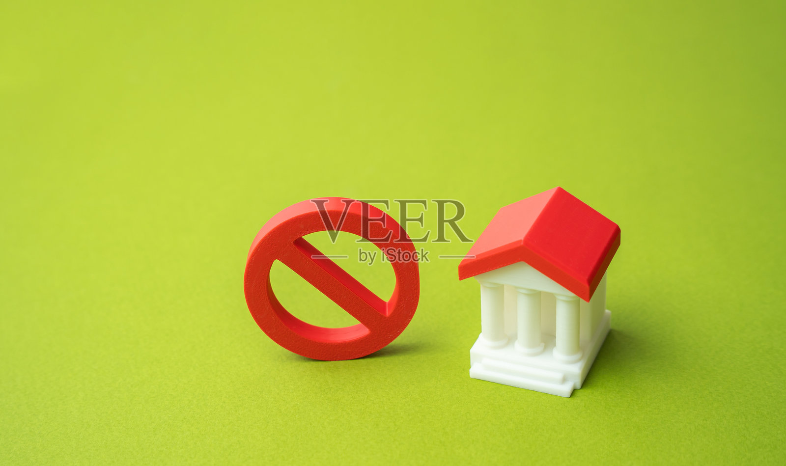 政府大楼或银行及“禁止”标志，背景为绿色。禁止和限制性法律的概念。禁令、刑事定罪、压制。吊销银行执照、国有化照片摄影图片