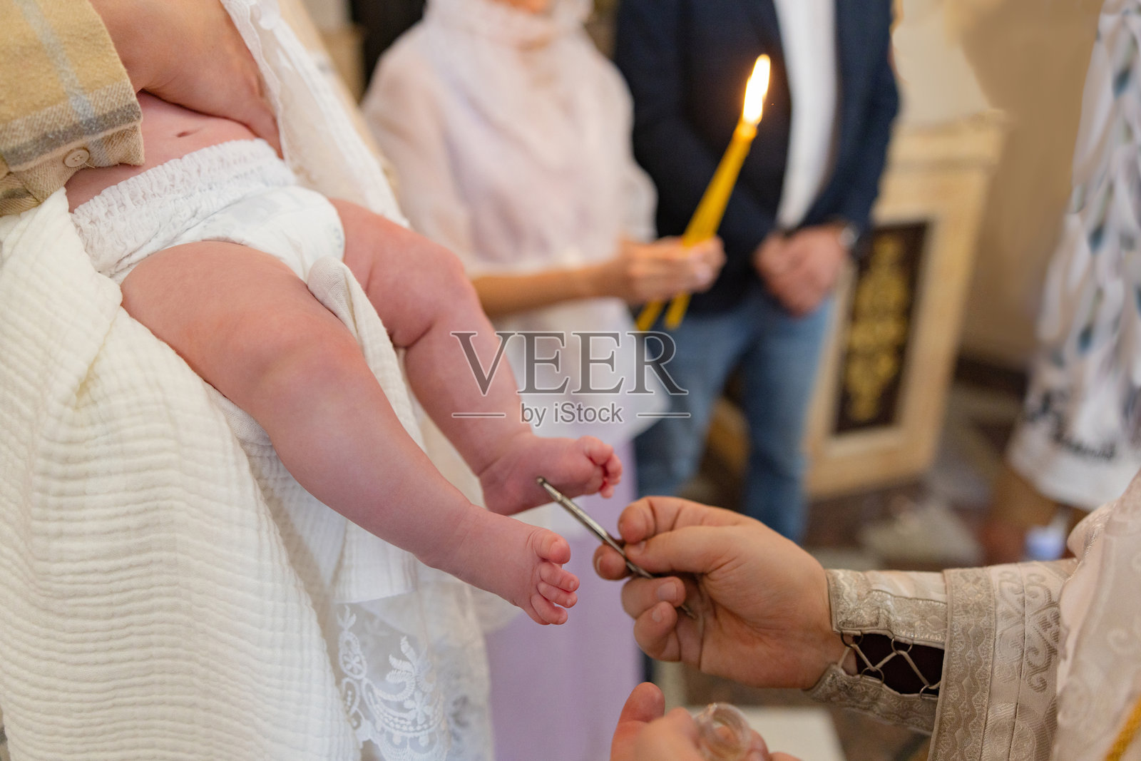 牧师在婴儿洗礼仪式上为婴儿傅油照片摄影图片