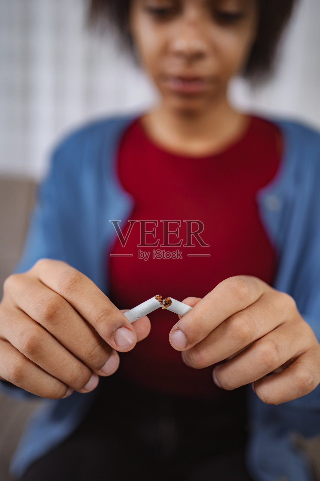 年轻女子折断香烟，戒烟照片摄影图片