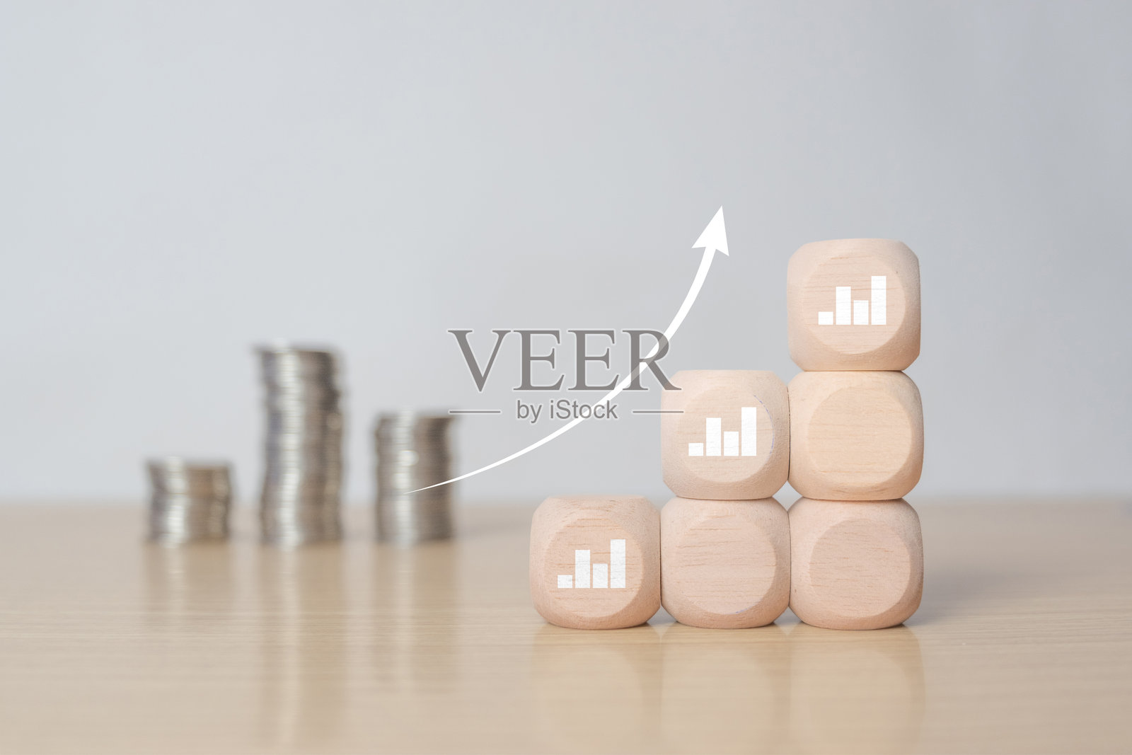 白色增长图表条形图，背景是模糊的硬币堆叠在木块上，代表储蓄、利润、通货膨胀、商业投资增长的概念照片摄影图片