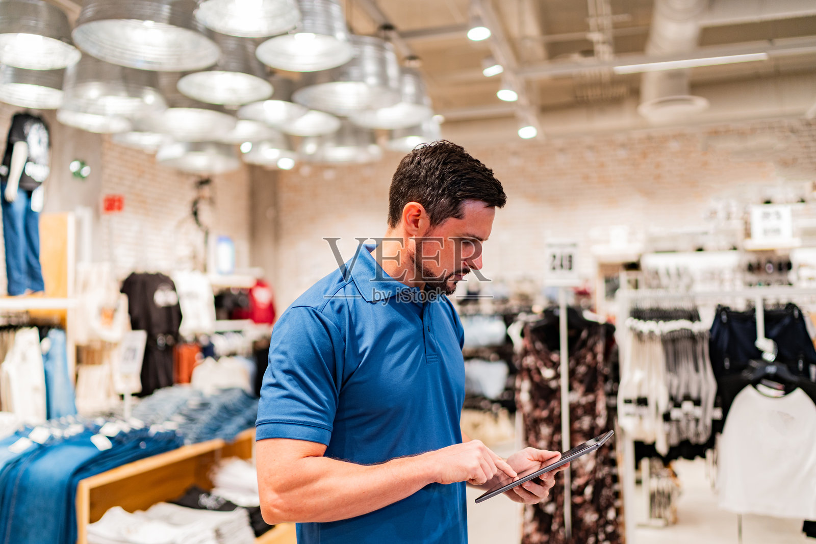 澳大利亚中年男销售在服装店盘点库存照片摄影图片