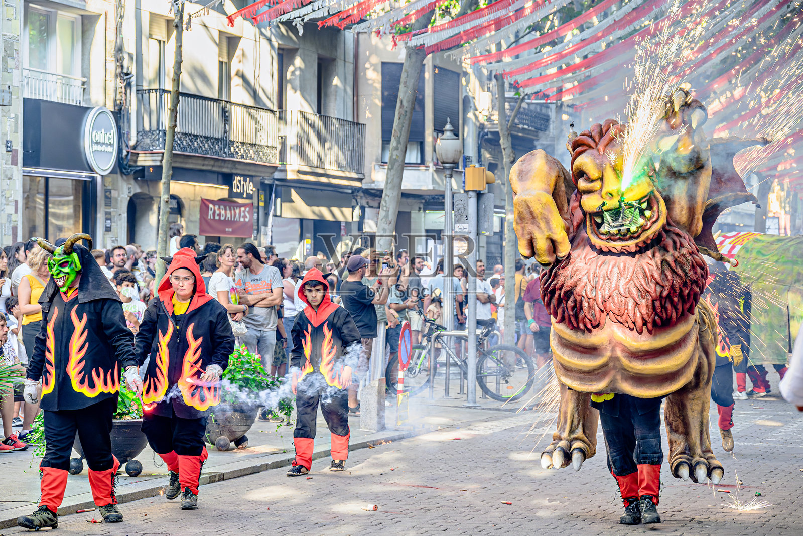 城市节庆活动，来自伊瓜拉达的Mal-Llamp团体进行correfocs（火舞）游行穿过街道。照片摄影图片