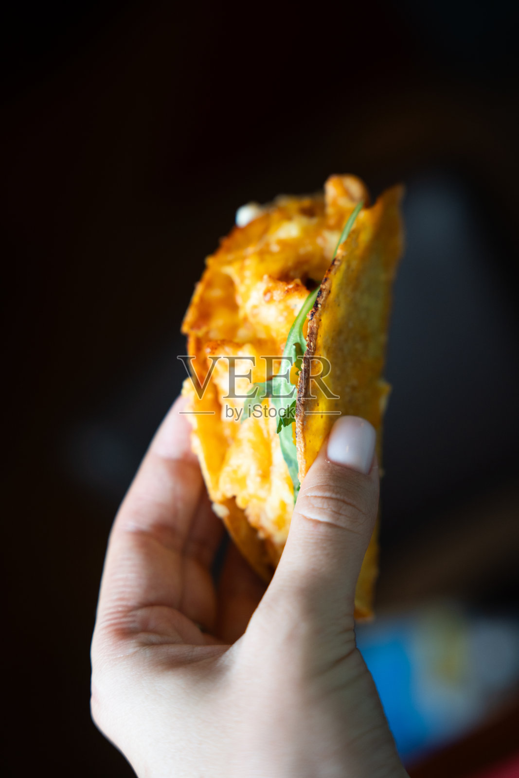 手持夹有奶酪和蔬菜的墨西哥玉米饼照片摄影图片