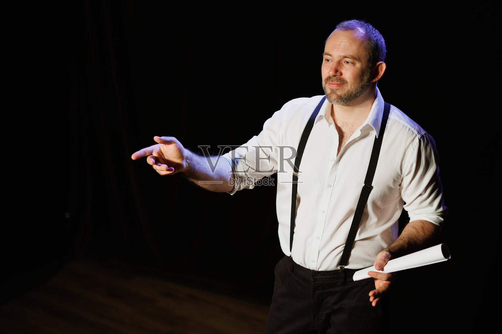 身穿衬衫的表演者在剧院舞台上拿着文件照片摄影图片