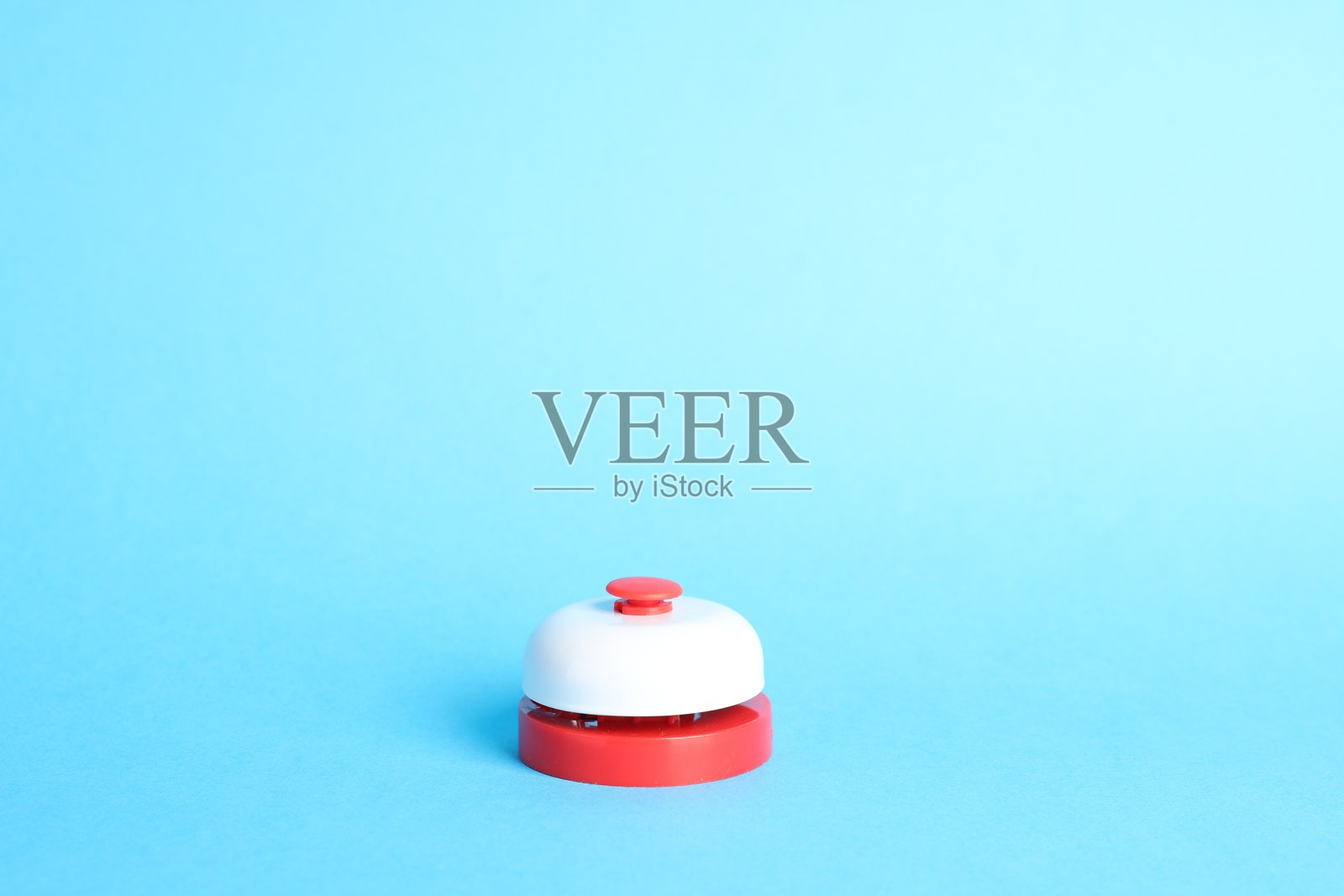 浅蓝色背景上的一个红色按钮，留有文字空间照片摄影图片