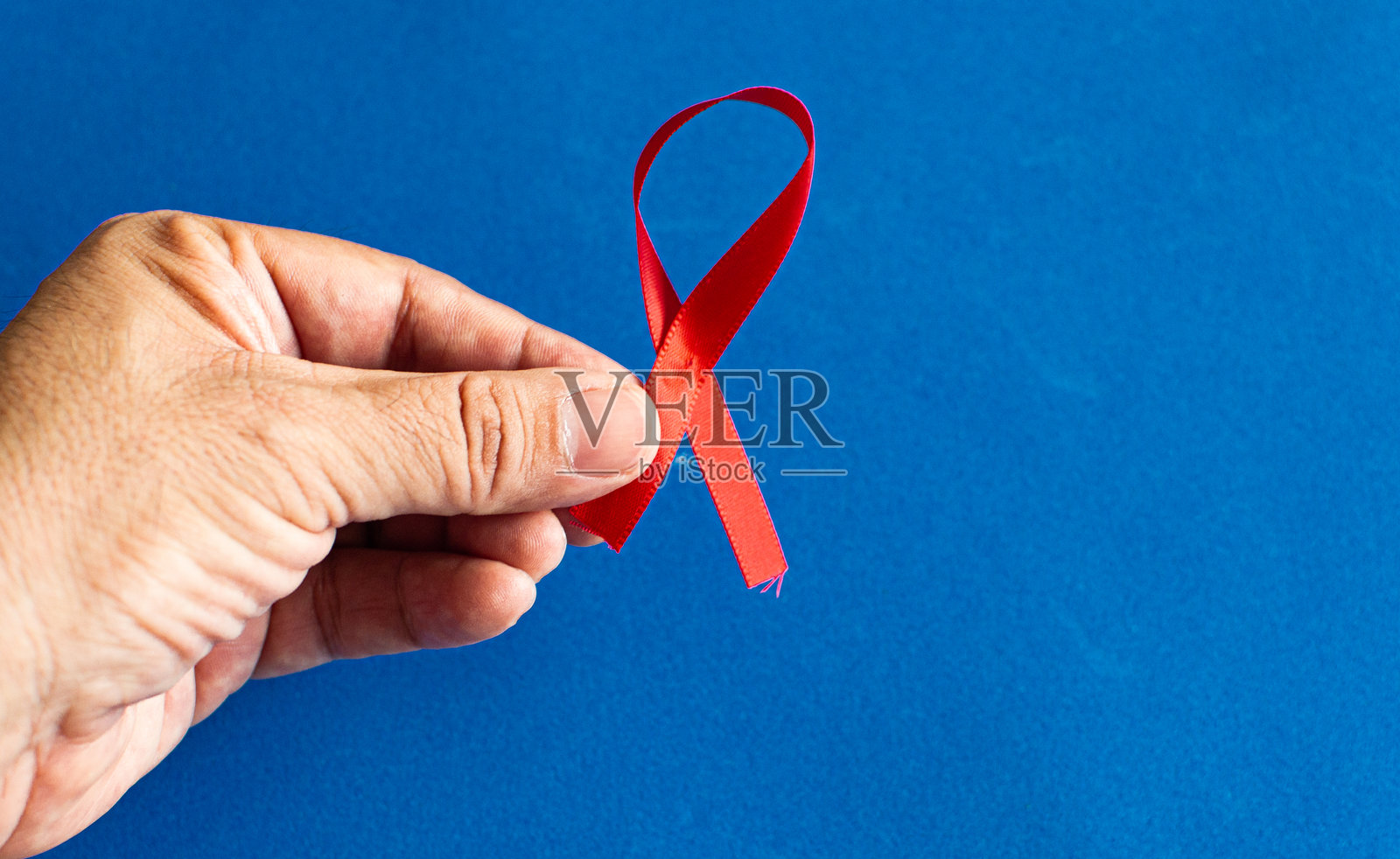 手持红色丝带，宣传世界艾滋病日照片摄影图片