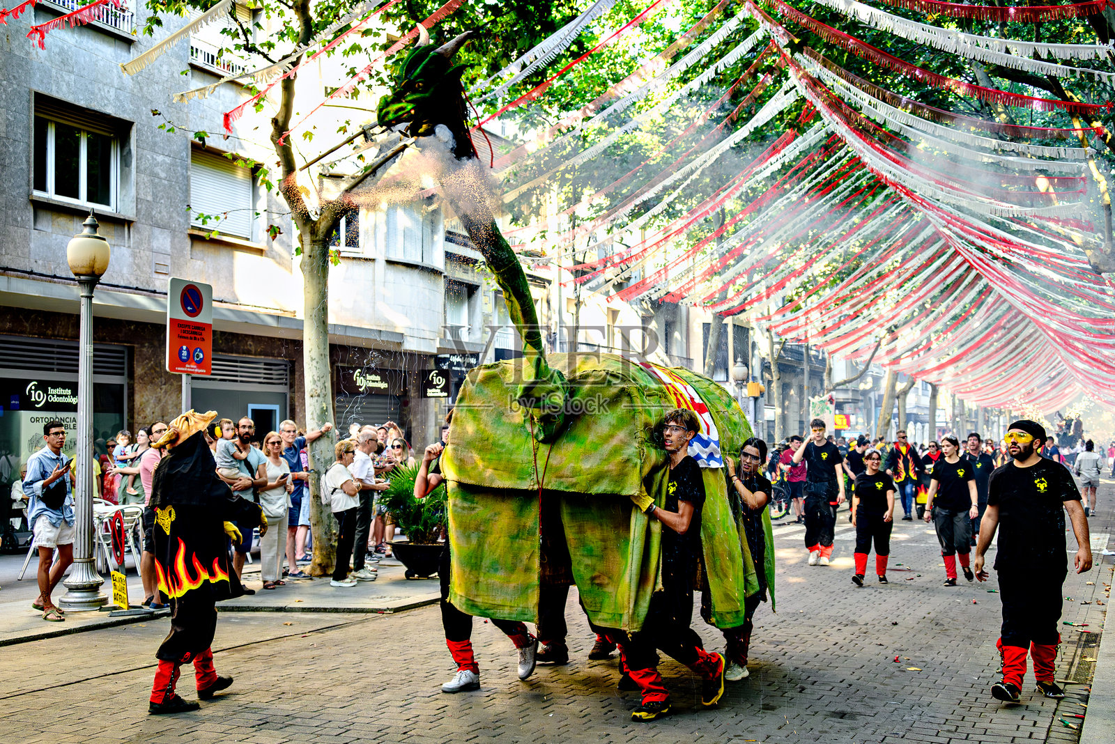 城市节日,伊瓜拉达的 Correfocs (火跑) La Guita Mal-Llamp 乐队在街道上游行。照片摄影图片