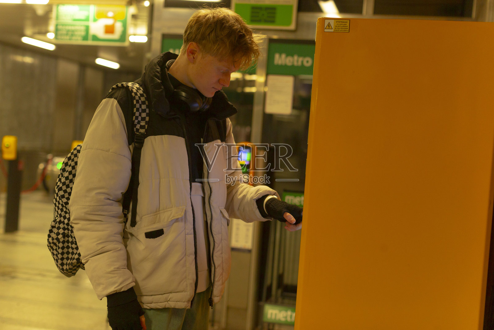 明亮的灯光下，一个人正在进行日常的地铁乘车交易照片摄影图片