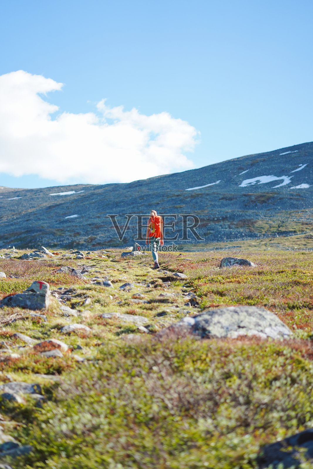 年轻女子徒步穿越山间草甸照片摄影图片