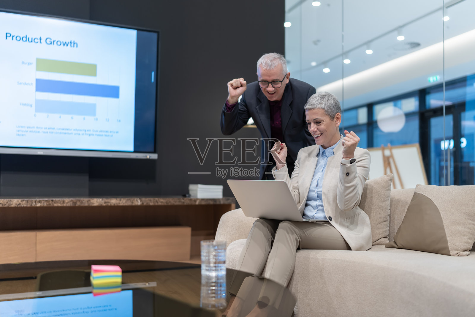 商务同事们在现代办公室庆祝产品增长成功照片摄影图片