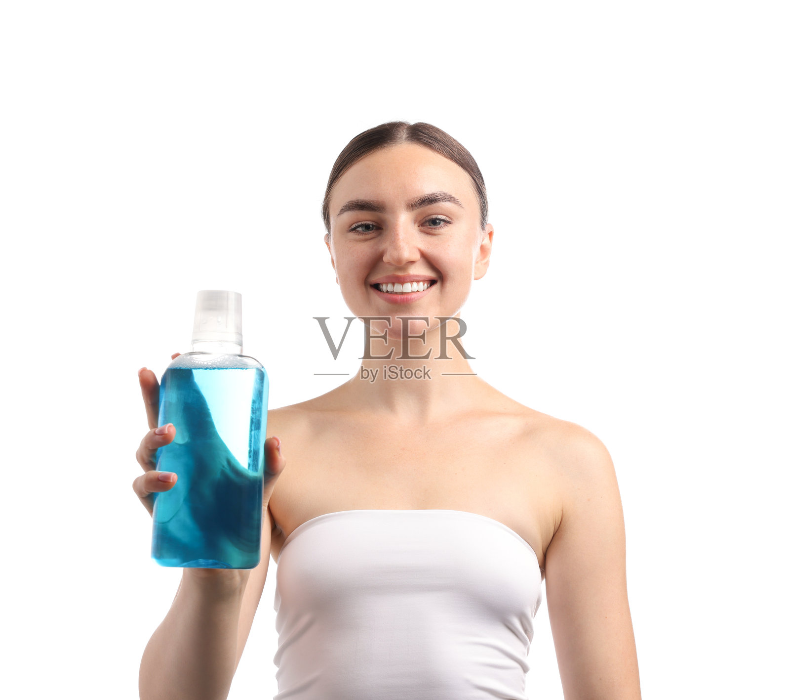 白色背景下，一名女子手持漱口水瓶，展现口腔护理照片摄影图片