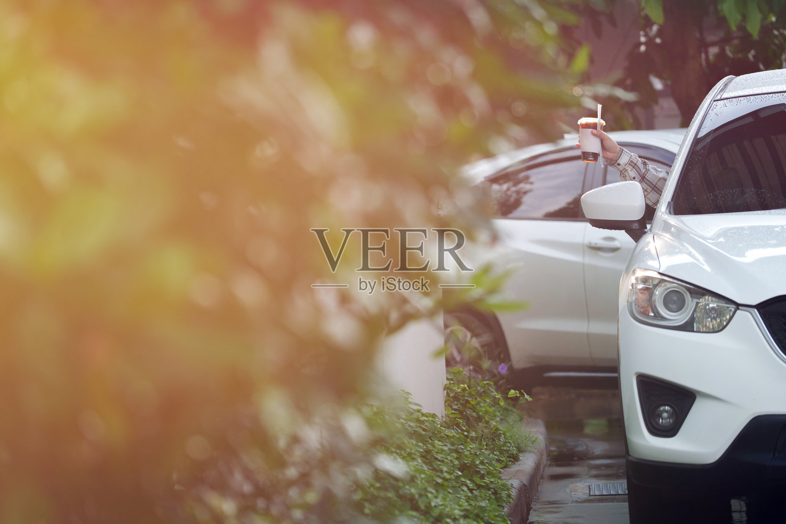 在高峰时段，顾客从得来速柜台的工作人员手中接过咖啡杯。照片摄影图片